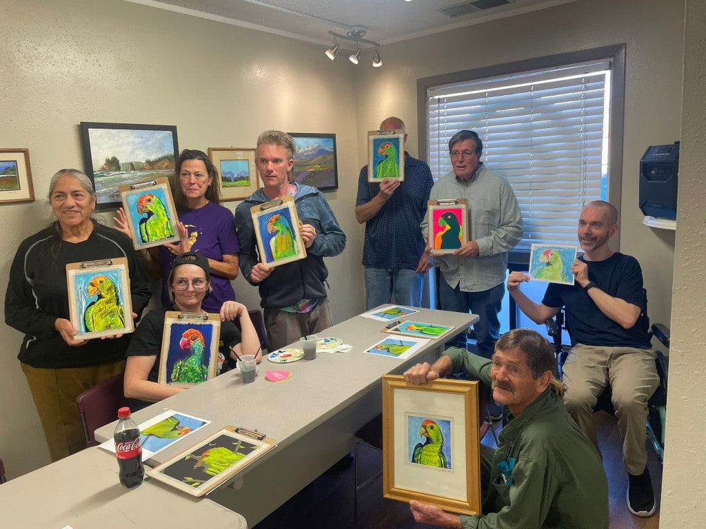 Community art class Green Thumb Initiative community art class with participants showing parrot paintings